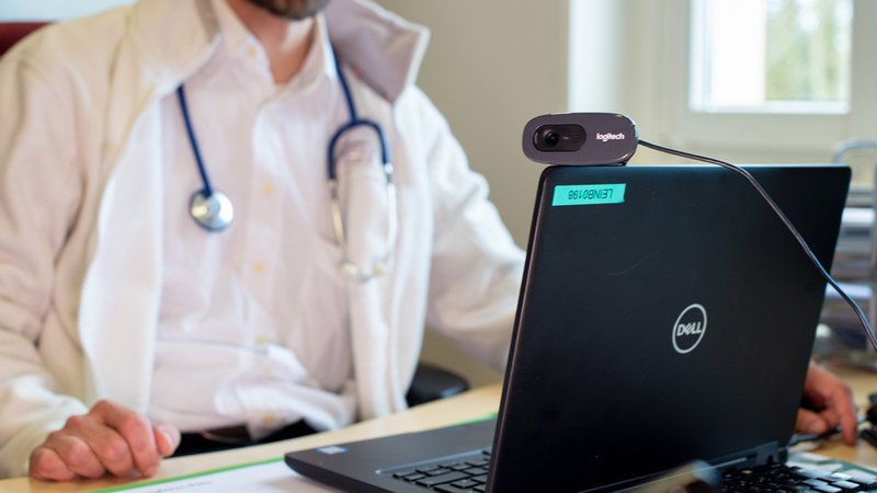 Ein Arzt spricht während einer Videosprechstunde in seiner Praxis mit einer Patientin | Bild: dpa-Bildfunk/Monika Skolimowska Ein Arzt spricht während einer Videosprechstunde in seiner Praxis mit einer Patientin
