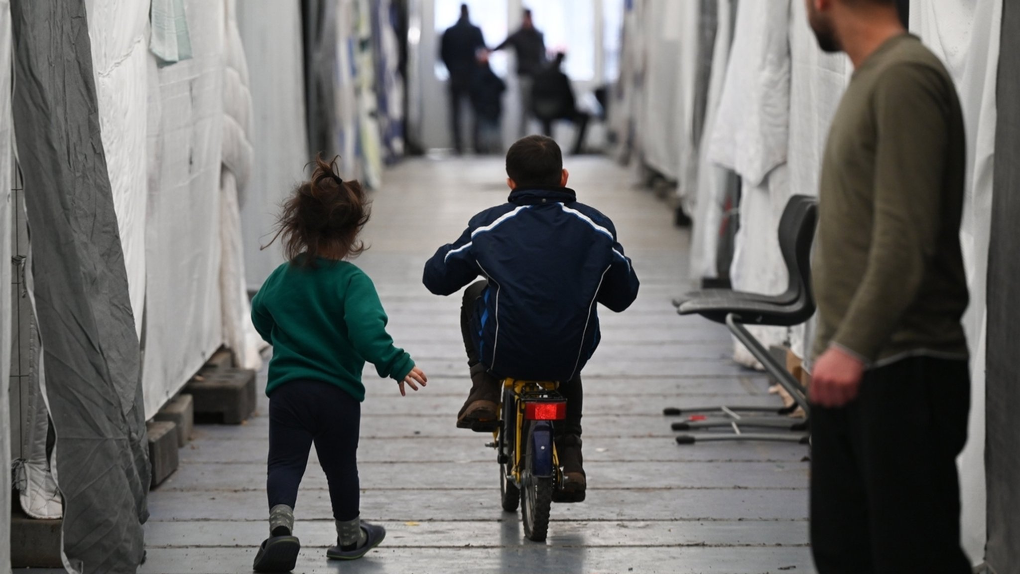 Flüchtlinge sind in einem der Zelte einer provisorischen Flüchtlingsunterkunft unterwegs (Archivbild).