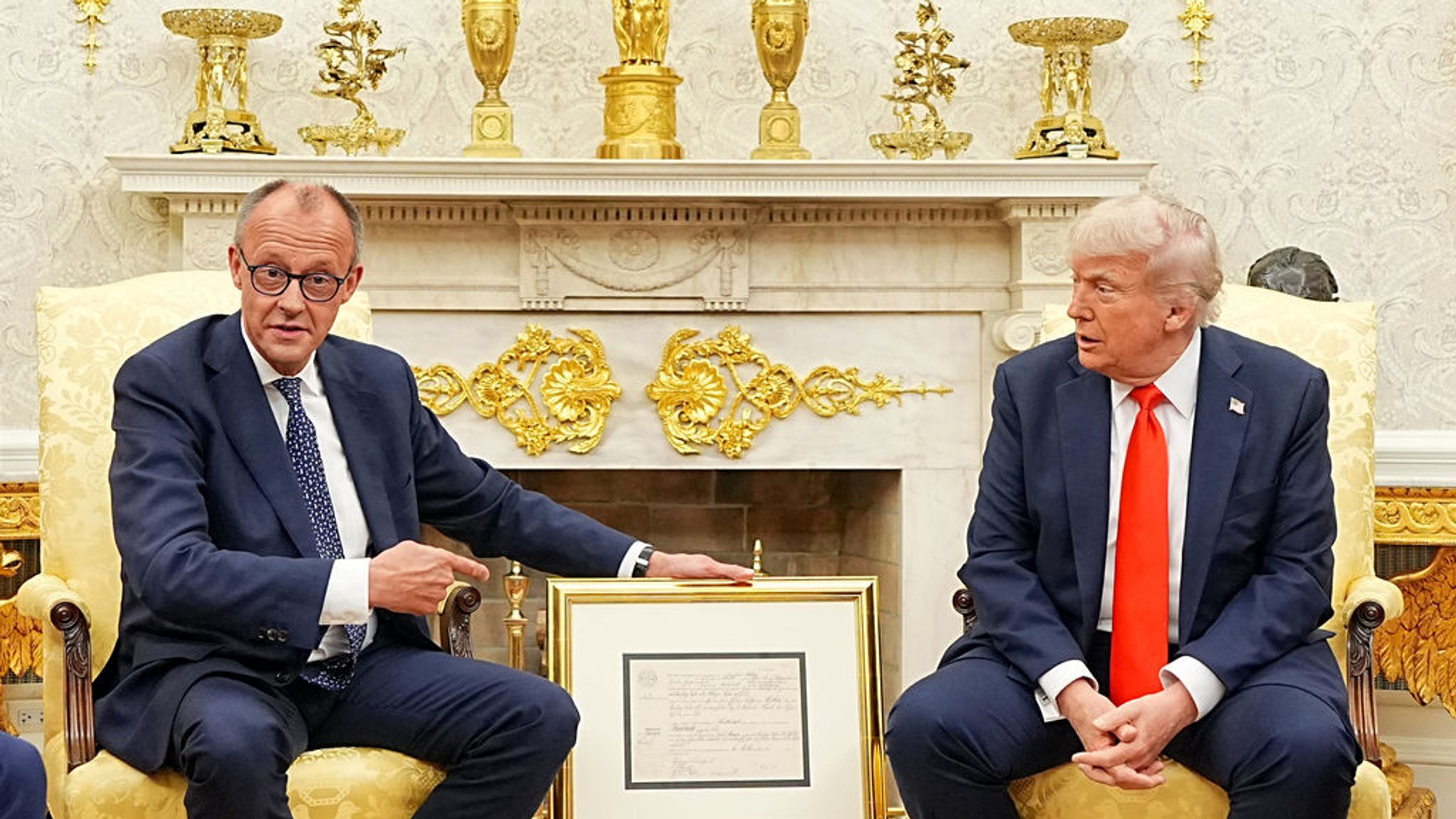 dpatopbilder - 05.06.2025, USA, Washington: US-Präsident Donald Trump (r) empfängt Bundeskanzler Friedrich Merz (CDU) im Oval Office im Weißen Haus. Merz überreichte ein Faksimile der Geburtsurkunde (oben deutsche, unten englische Fassung) von Friedrich (später Frederick) Trump, Großvater von US-Präsident Donald Trump als Gastgeschenk. Es ist das erste Treffen zwischen beiden Politikern seit Amtsantritt von Trump und Merz. Foto: Michael Kappeler/dpa Pool/dpa +++ dpa-Bildfunk +++