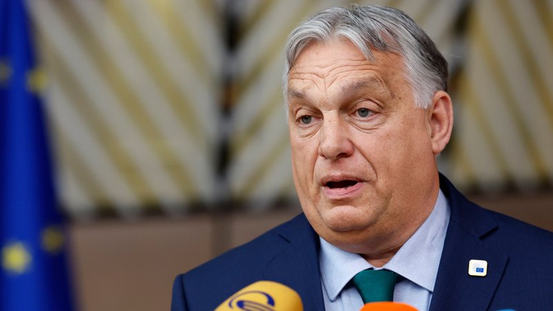 Ungarns Ministerpräsident Viktor Orban in dunklem Anzug vor Mikrofonen.