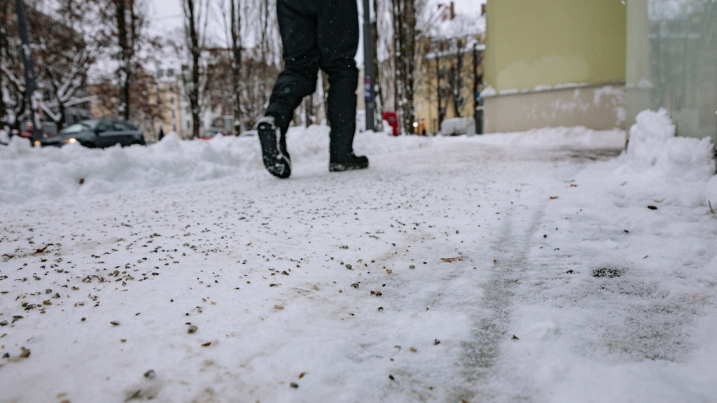 Streusplit auf einem schneebedeckten Fußweg.
