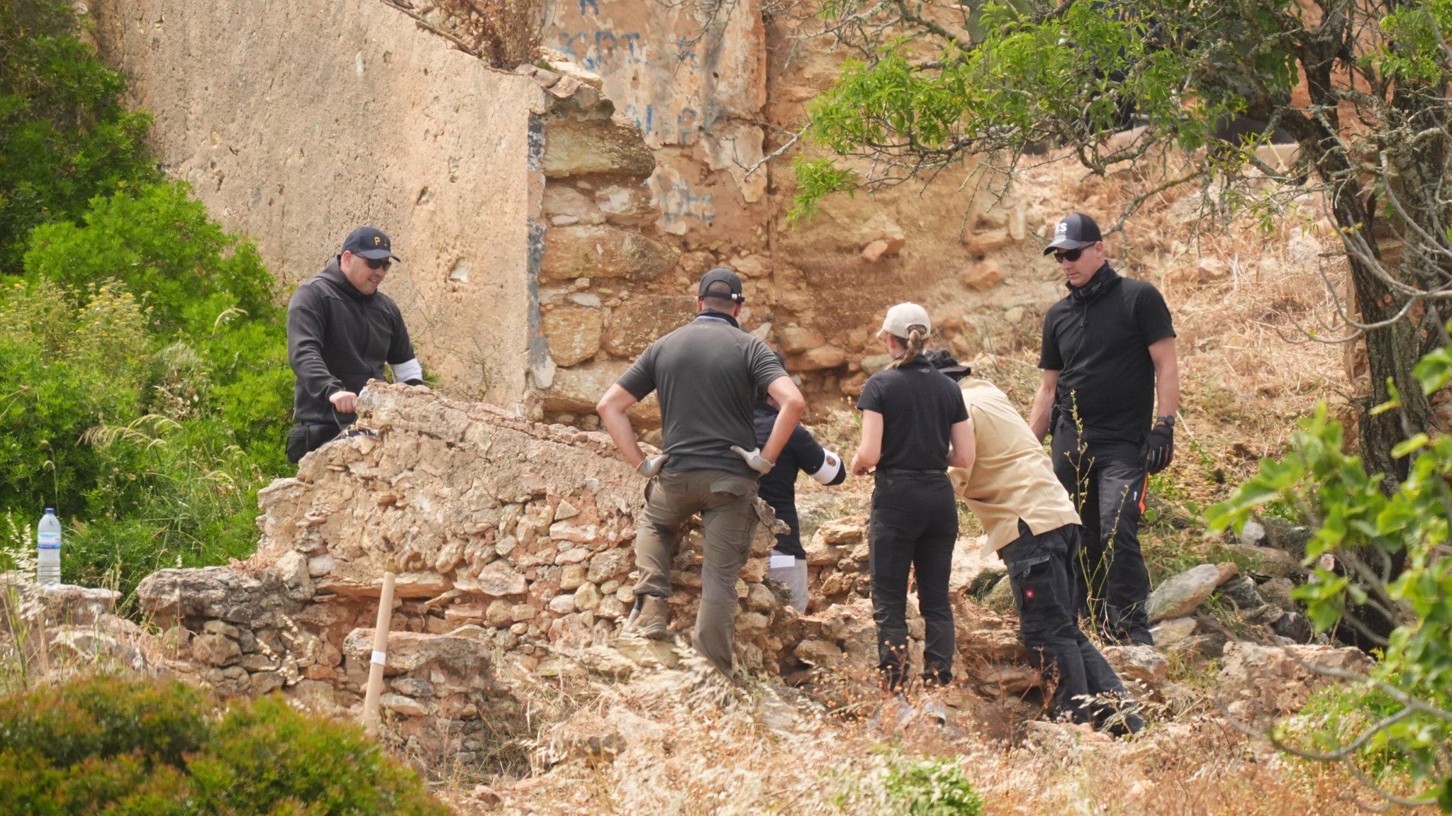 Suchtruppen durchforsten ein verlassenes Grundstück an der Praia de Luz in Portugal. | Bild: picture alliance / empics | James Manning Suchtruppen durchforsten ein verlassenes Grundstück an der Praia de Luz in Portugal.