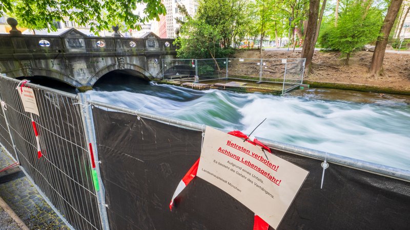 Ein Schild mit der Aufschrift "Betreten verboten! Achtung Lebensgefahr!" hängt am 23.4.2025 an einer Absperrung vor der künstlichen Welle am Eisbach. | Bild: dpa-Bildfunk/Peter Kneffel Ein Schild mit der Aufschrift "Betreten verboten! Achtung Lebensgefahr!" hängt am 23.4.2025 an einer Absperrung vor der künstlichen Welle am Eisbach.