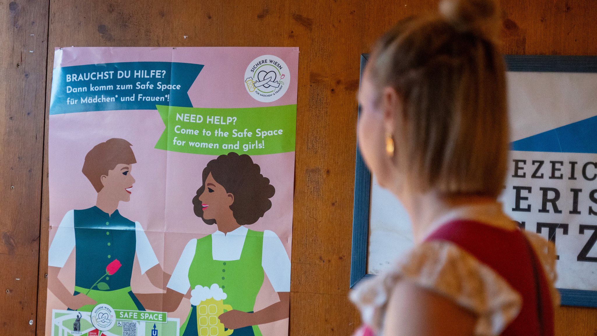 Ein Plakat mit Hinweisen zu einem Safe-Space für Mädchen und Frauen hängt in einem Festzelt auf dem Oktoberfest. 