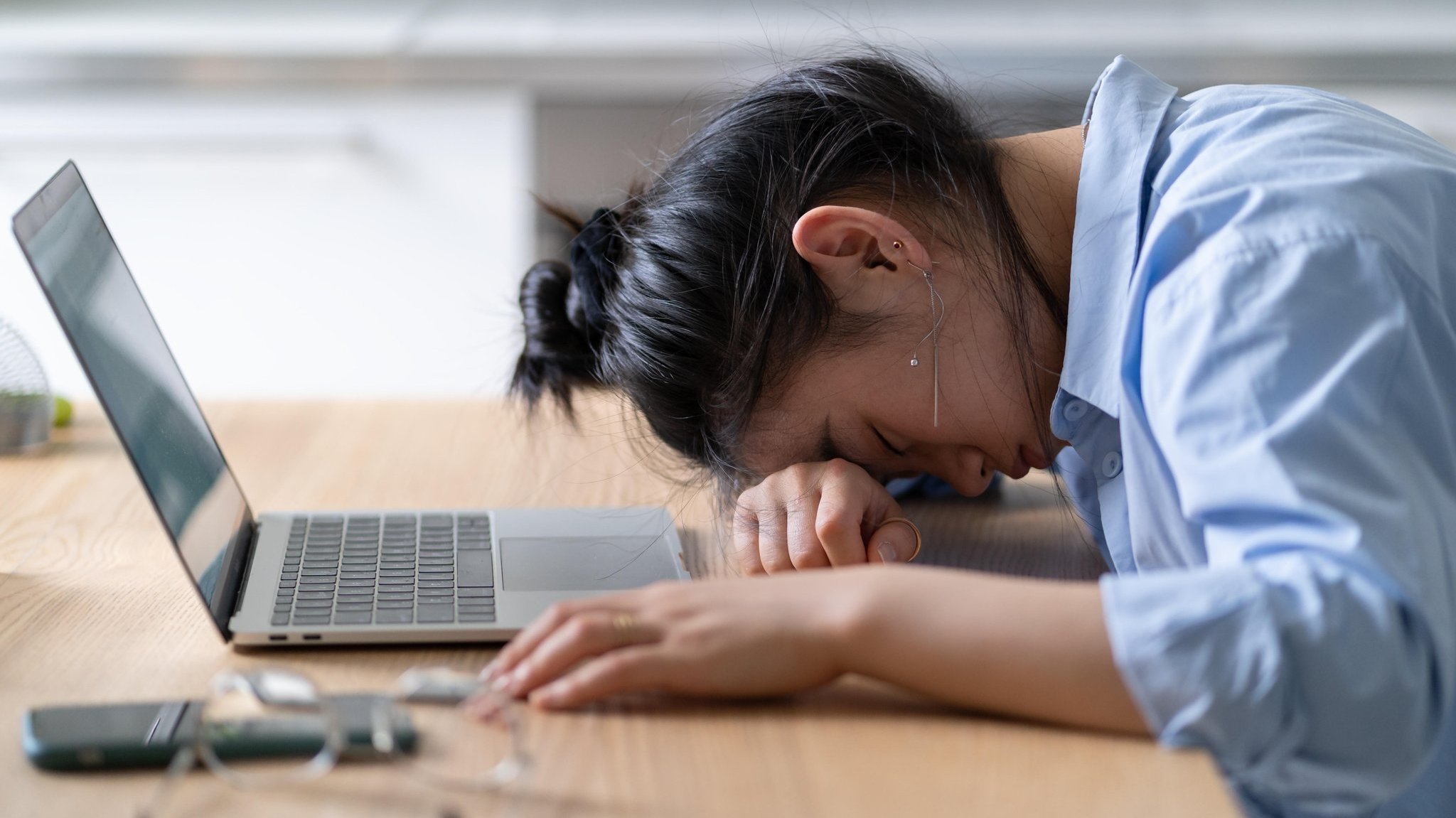 Junge Frau erschöpft vor Notebook