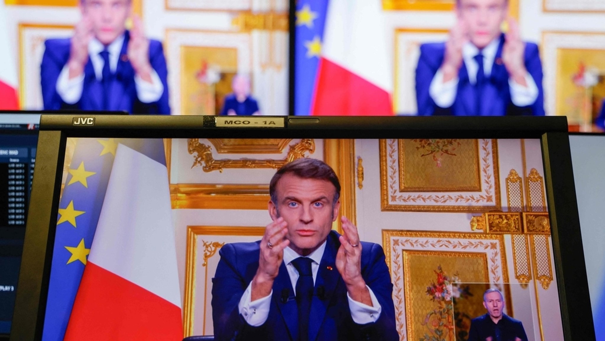 05.12.2024, Frankreich, Paris: Der französische Präsident Emmanuel Macron ist auf Monitoren in einem Kontrollraum im AFP-Hauptquartier zu sehen, als er sich während einer Fernsehübertragung aus dem Elysee-Palast an die Nation wendet.