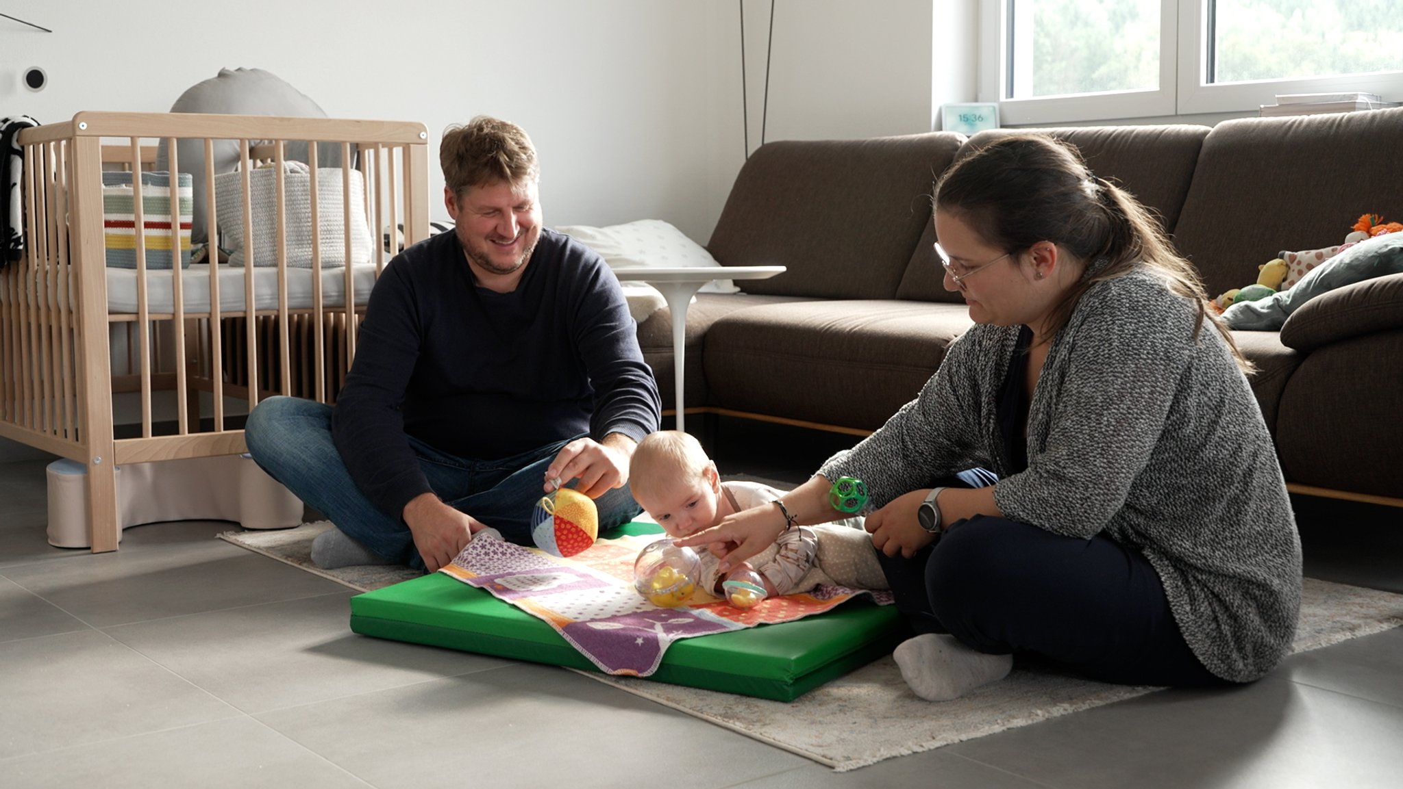 Ina Biedermann und Konrad Schmid sitzen mit ihrem kleinen Paul auf dem Boden des heimischen Wohnzimmers. Der sechs Monate alte Säugling hat erkennbare Schwächen auf der linken Körperseite. 