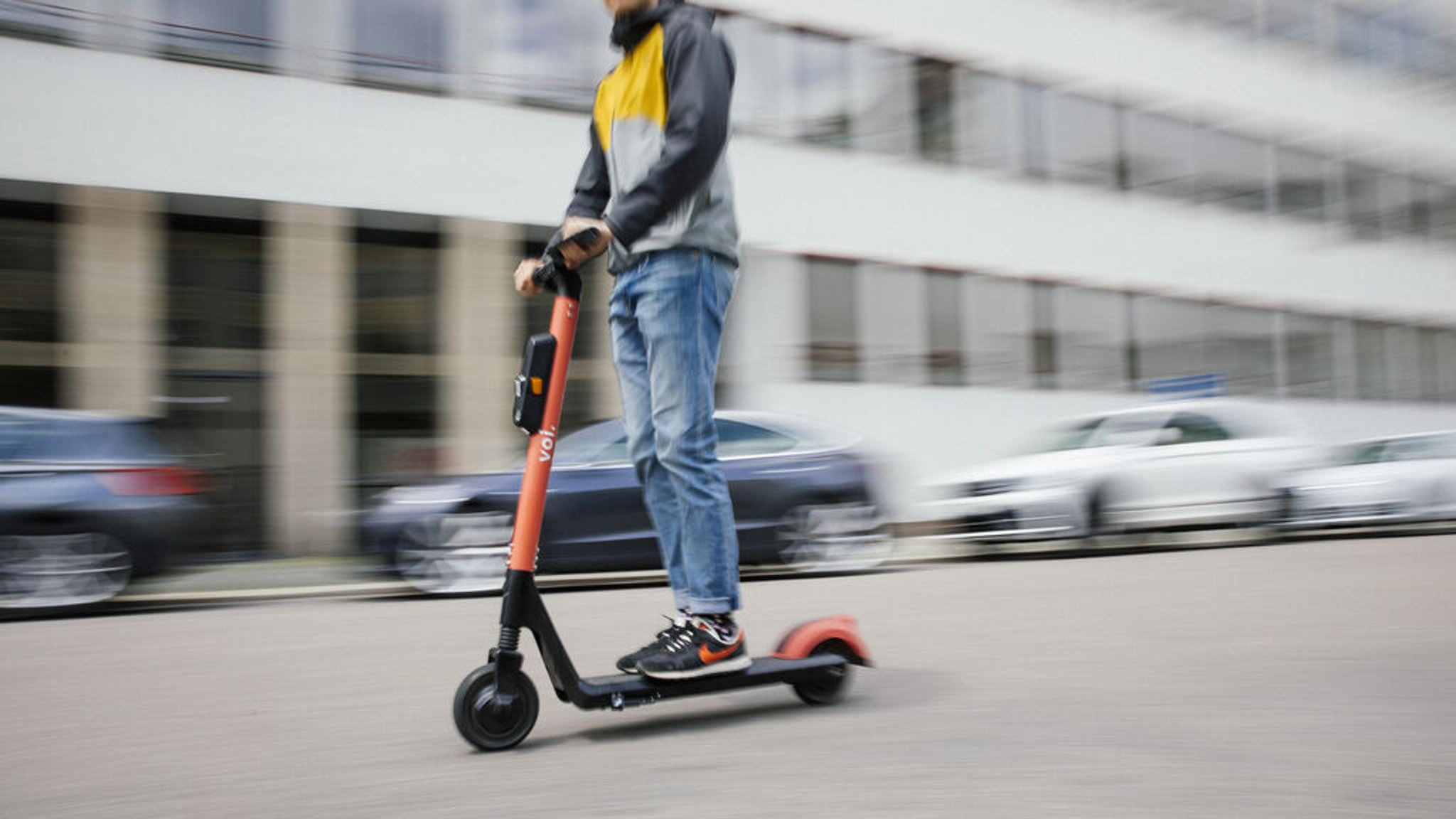 Eine Person fährt mit einem Elektroroller auf der Straße.