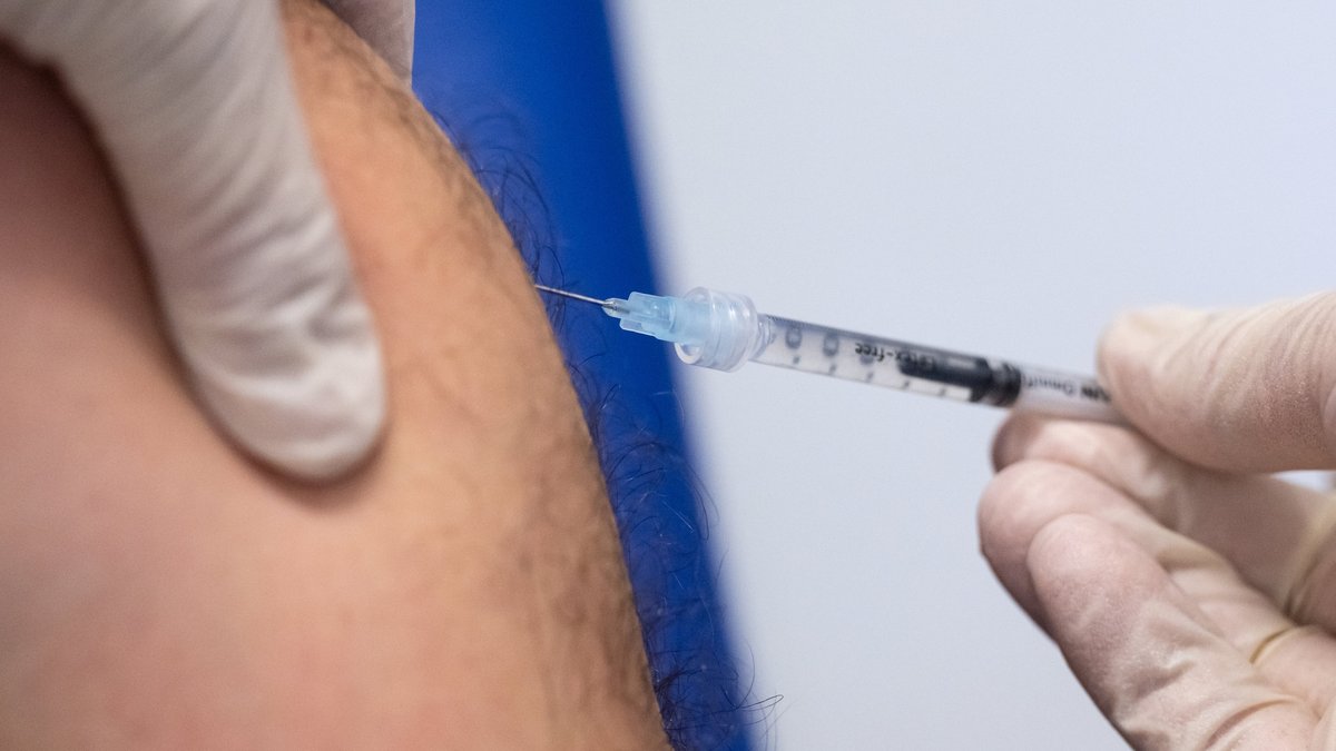 Ein Mitarbeiter impft im Klinikum rechts der Isar einen Mann mit dem Impfstoff von Bavarian Nordic (Imvanex/Jynneos) gegen Affenpocken.