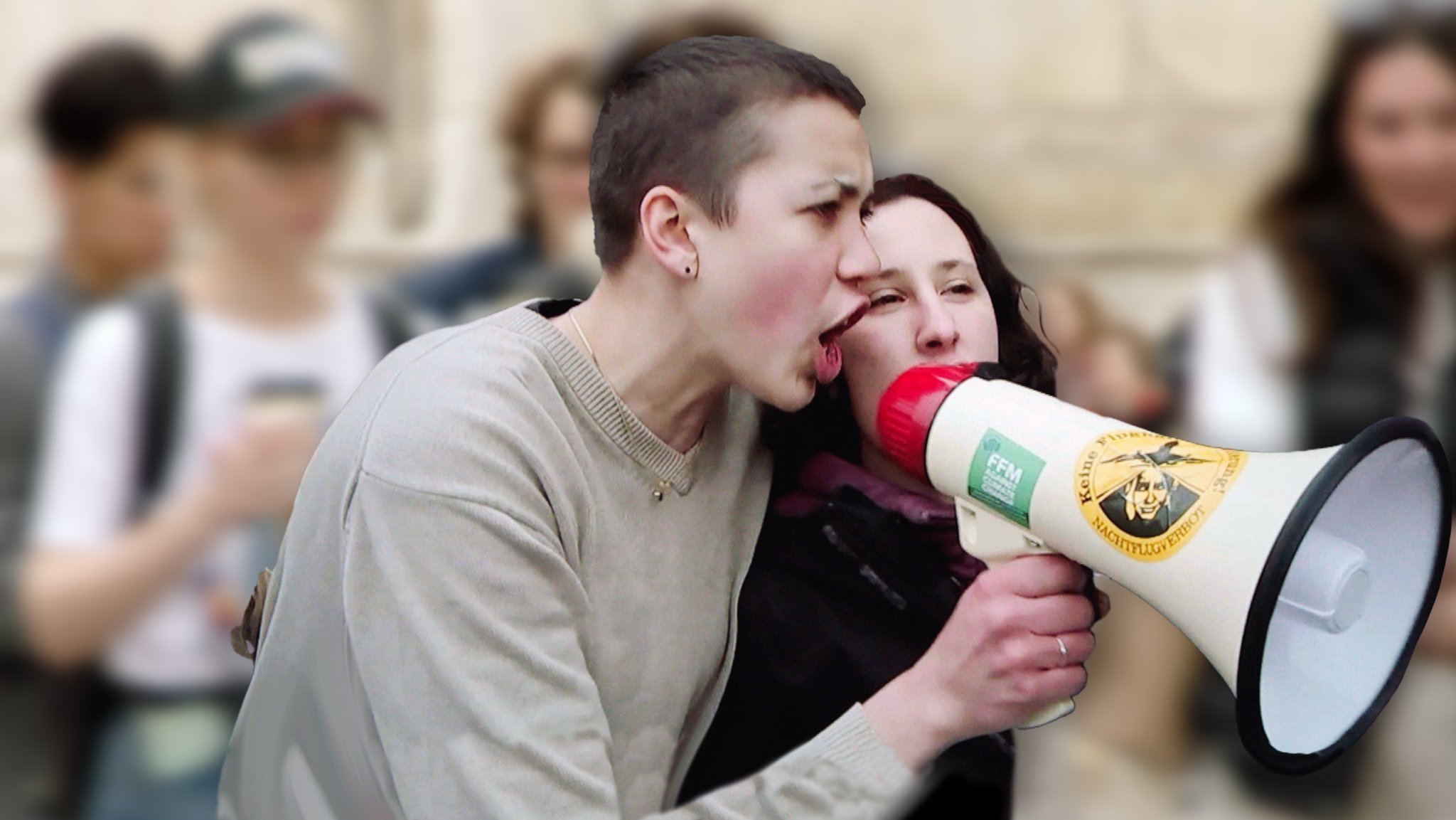 Zwei junge Frauen mit Megaphone auf einer Demo.