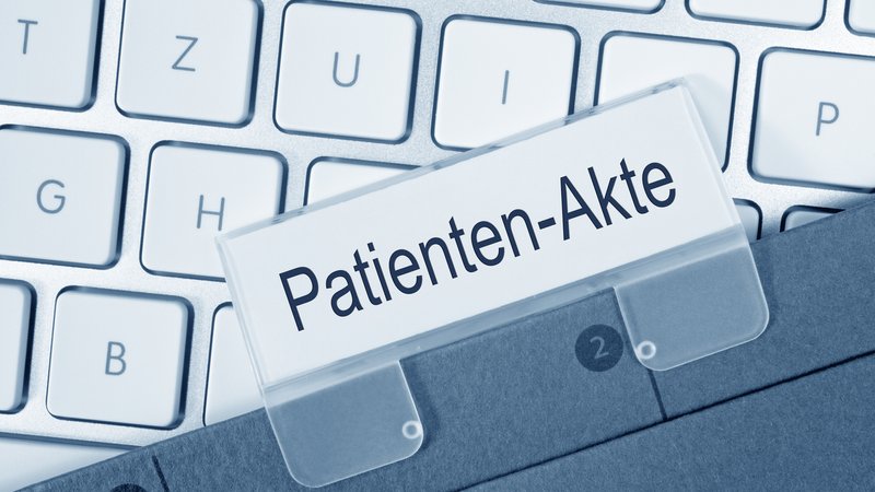 Eine Patienten-Akte liegt auf einer Tastatur