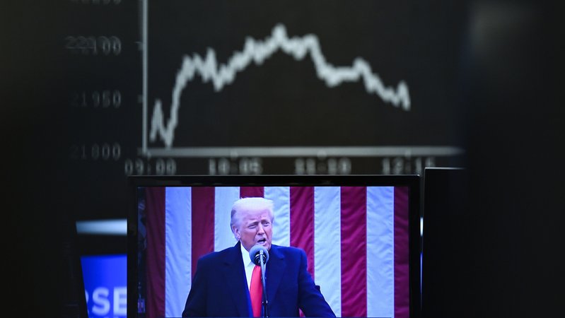 Hinter einem Fernsehmonitor, auf dem US-Präsident Donald Trump zu sehen ist, zeigt die Anzeigetafel mit der Dax-Kurve fallende Kurse. | Bild: picture alliance/dpa|Arne Dedert Hinter einem Fernsehmonitor, auf dem US-Präsident Donald Trump zu sehen ist, zeigt die Anzeigetafel mit der Dax-Kurve fallende Kurse.