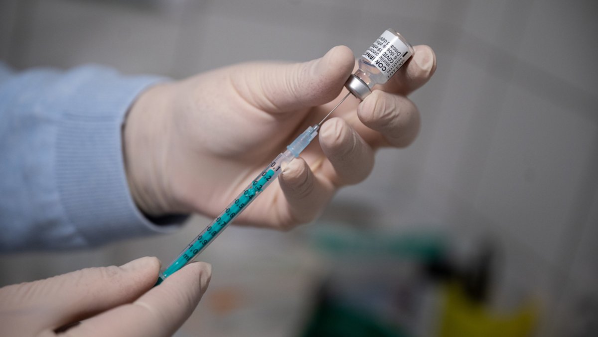 Ein Arzt zieht in einer Hausarztpraxis eine Spritze mit dem Impfstoff von Pfizer/Biontech auf