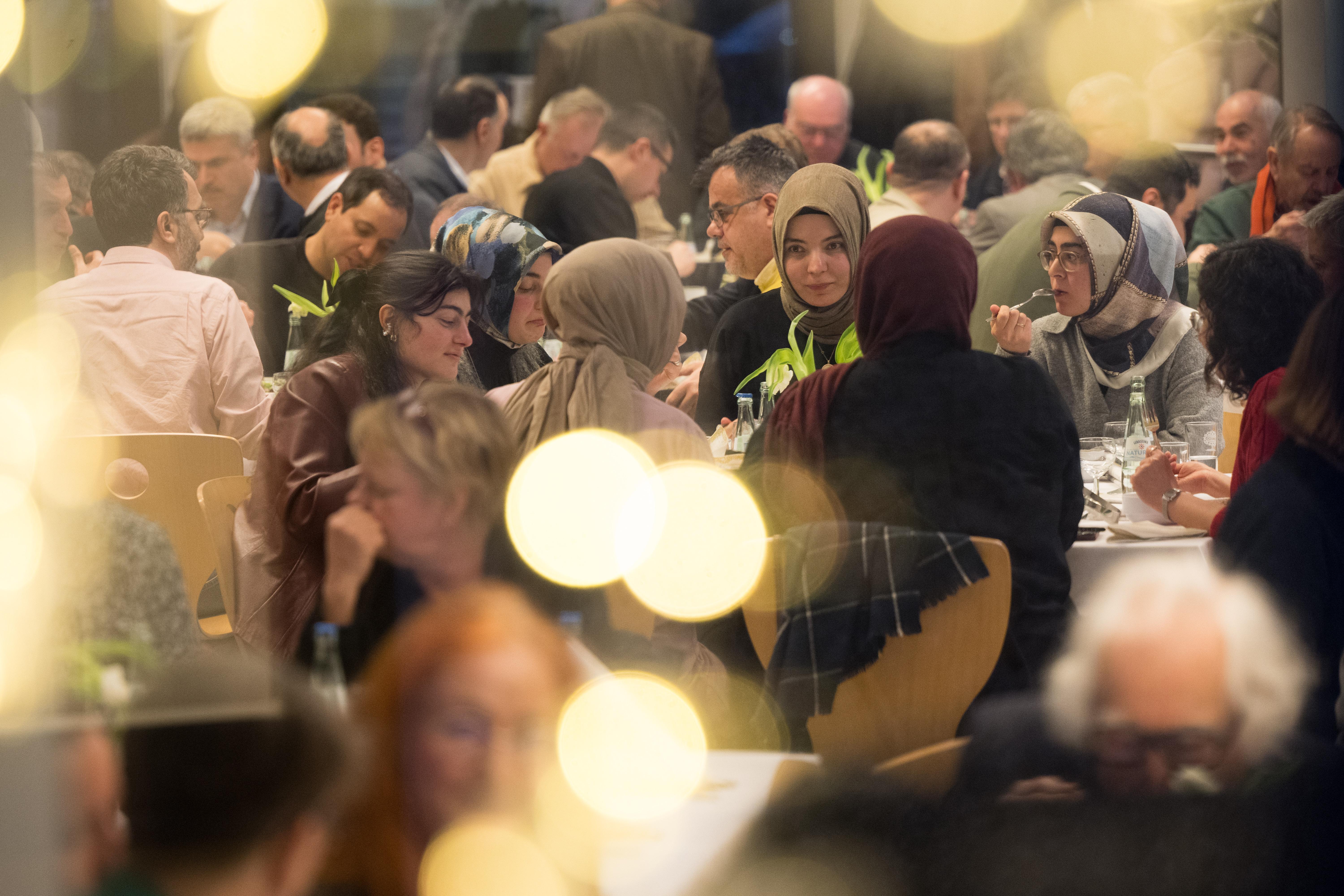 Gäste nehmen an einem gemeinsamen Fastenbrechen im Ramadan der interreligiösen Organisation House of One in Berlin teil.