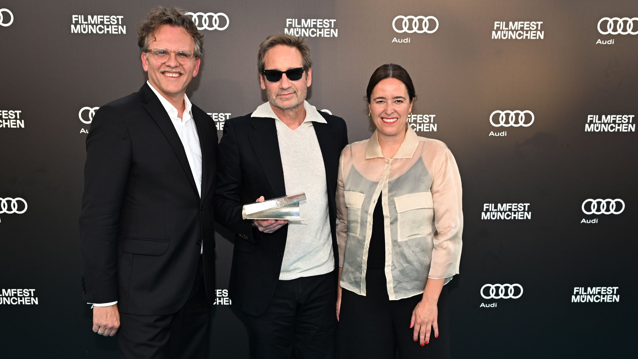Dem US-Schauspieler David Duchovny (M.) wurde beim Filmfest München der CineMerit-Award verliehen; im Bild mit Filmfest-Leiter Christoph Gröner und künstlerischer Leiterin Julia Weigl. | Bild: dpa-Bildfunk/Felix Hörhager Dem US-Schauspieler David Duchovny (M.) wurde beim Filmfest München der CineMerit-Award verliehen; im Bild mit Filmfest-Leiter Christoph Gröner und künstlerischer Leiterin Julia Weigl.