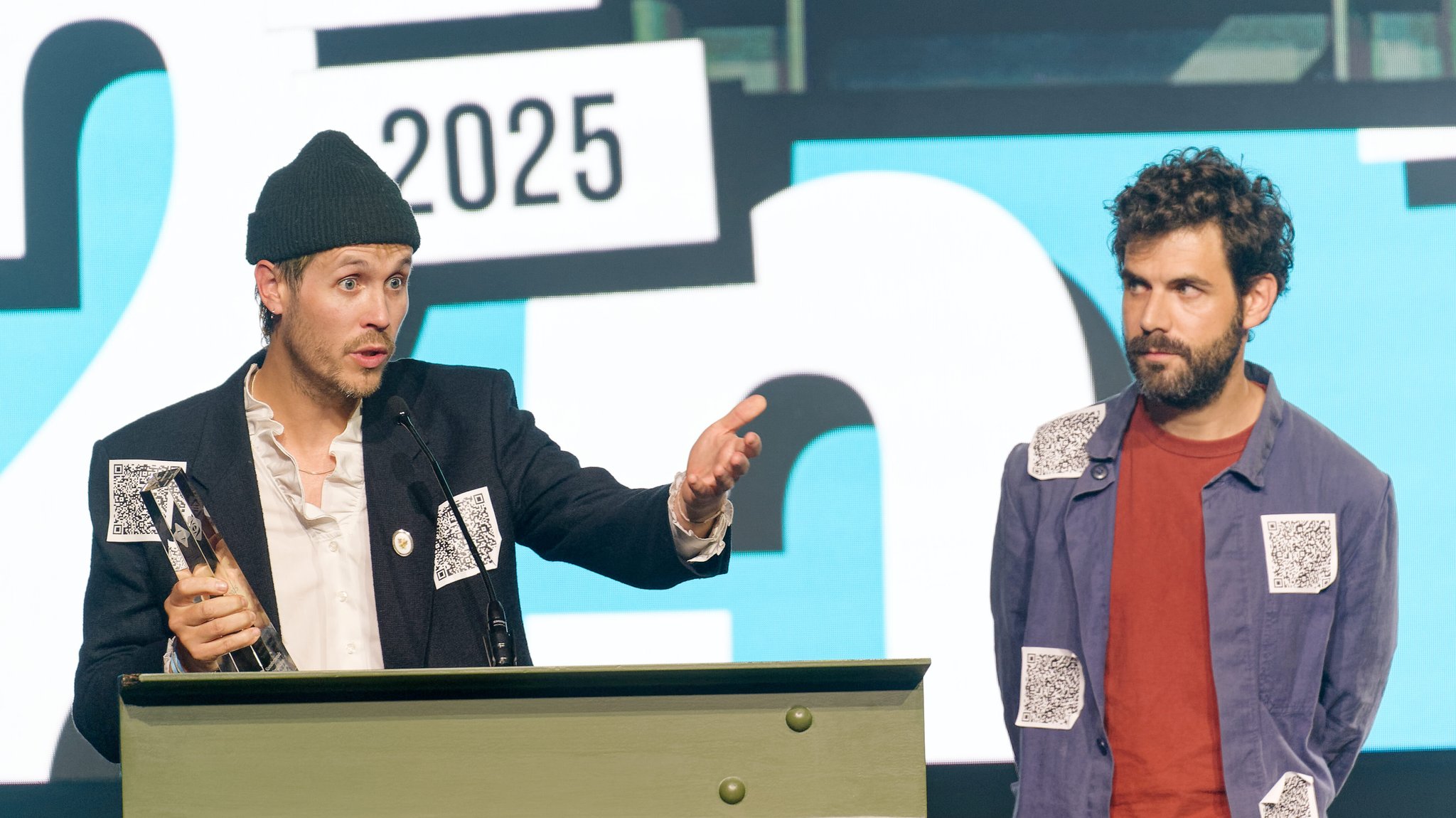 Die Regisseure Hans Block (l), Moritz Riesewieck (r) lassen bei Verleihung der Grimme-Online-Awards ihren Preis in der Kategorie "Sonderpreis Künstliche Intelligenz" auf der Bühne stehen, um gegen Aberkennung Bert-Donnepp-Preis von der Aktivistin Judith Scheytt zu Protestieren.
