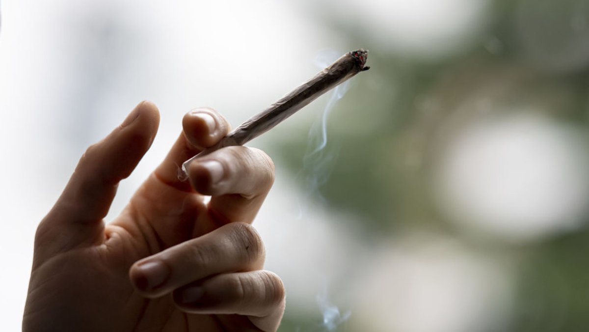 Eine Hand hält einen Joint - die mögliche Freigabe von Cannabis ist umstritten 