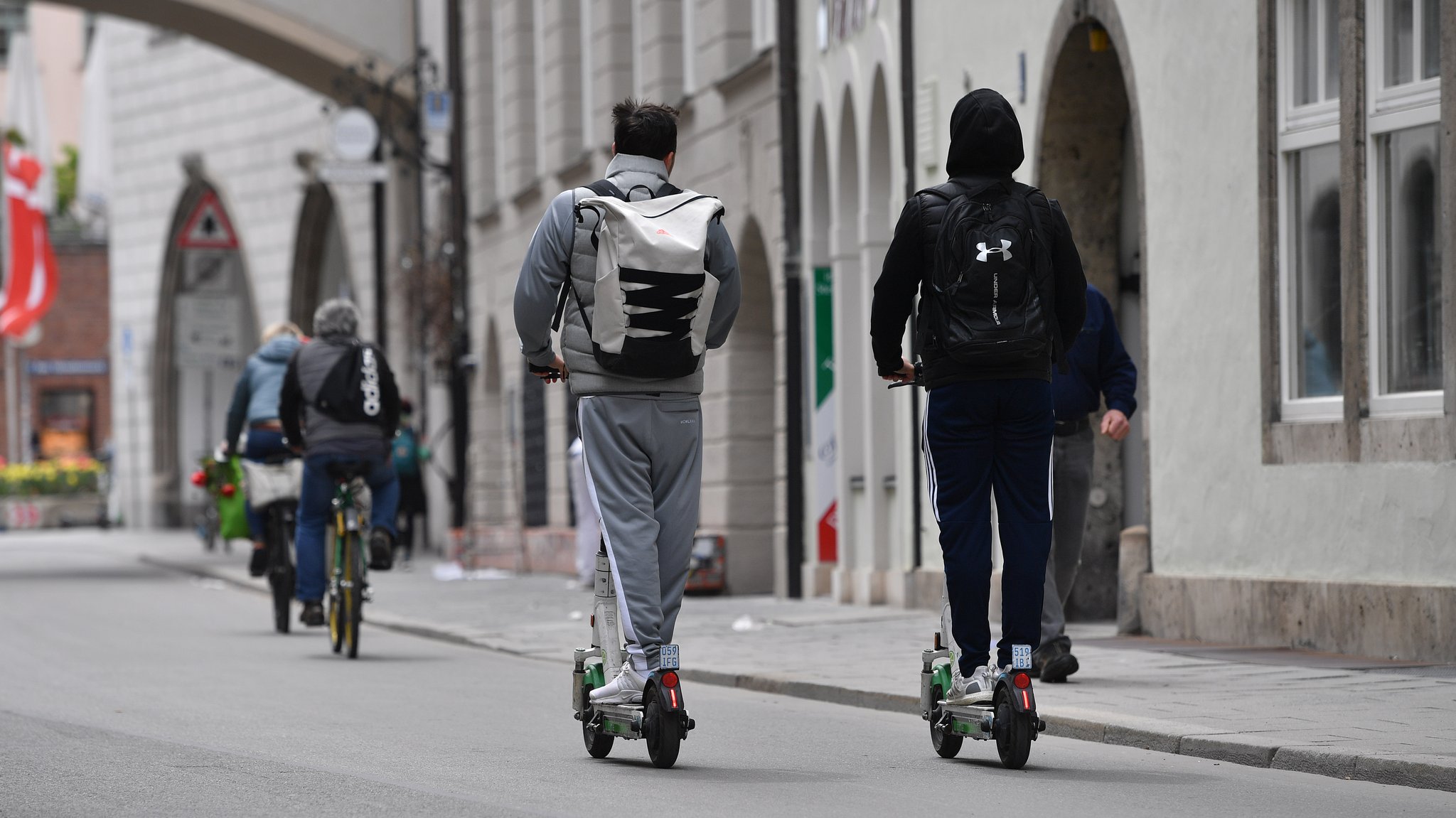 E-Scooter, Radfahrer und Fußgänger auf der Straße im Stadtzentrum in München.