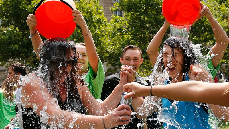Junge Menschen werden für die Ice Bucket Challenge mit eimerweise Eiswasser übergossen. | Bild: picture alliance / AP Photo | Elise Amendola Junge Menschen werden für die Ice Bucket Challenge mit eimerweise Eiswasser übergossen.