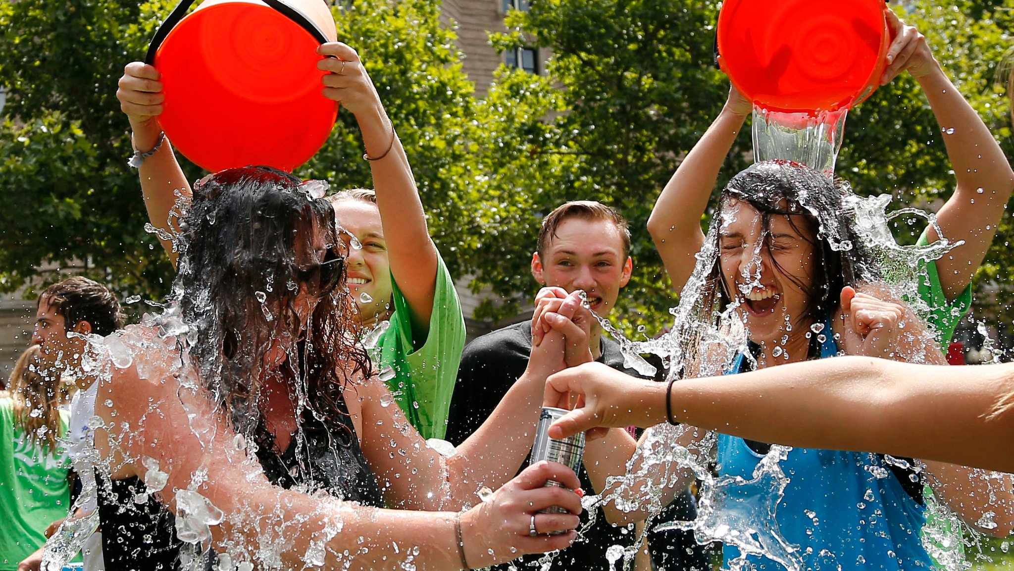 Junge Menschen werden für die Ice Bucket Challenge mit eimerweise Eiswasser übergossen.