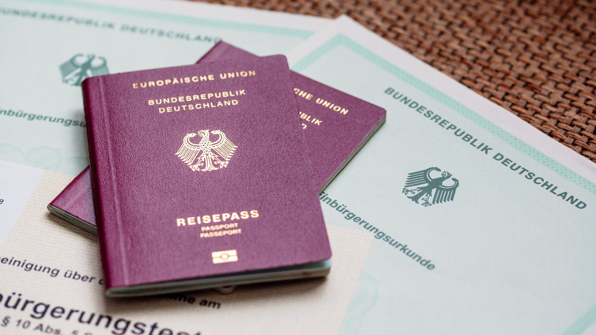 Zwei deutsche Reisepässe liegen auf Einbürgerungsurkunden der Bundesrepublik Deutschland. (Symbolbild) | Bild: dpa-Bildfunk/Fernando Gutierrez-Juarez Zwei deutsche Reisepässe liegen auf Einbürgerungsurkunden der Bundesrepublik Deutschland. (Symbolbild)