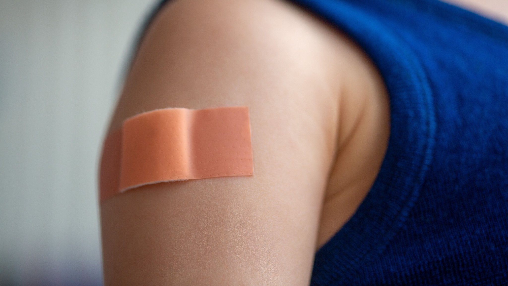Das Bild zeigt den Oberarm eines Kindes mit einem Pflaster darauf.