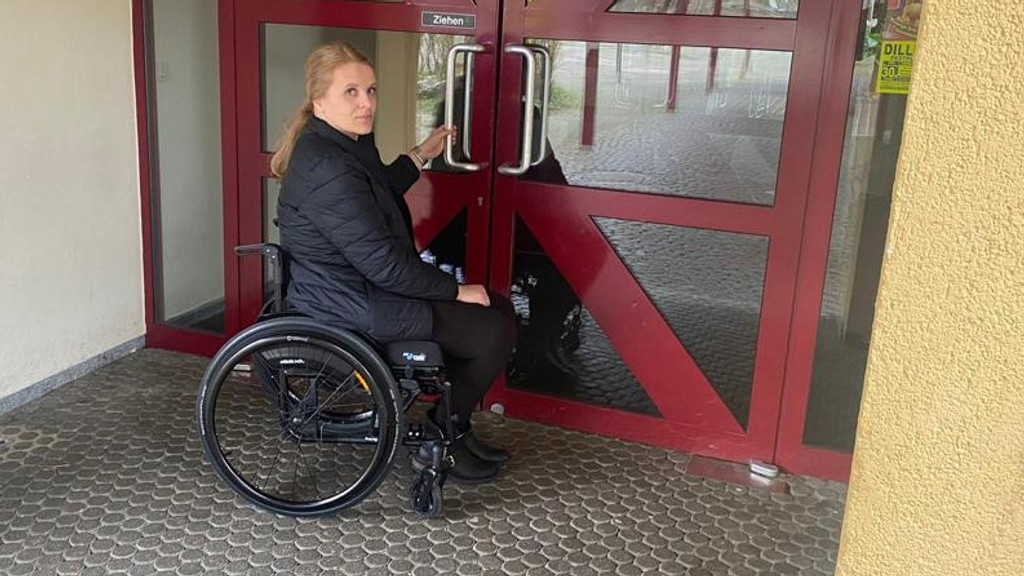 Kerstin Rathgeb im Rollstuhl vor der Tür zur Wittislinger Grundschule. Sie ist für sie ohne Hilfe nicht zu öffnen.