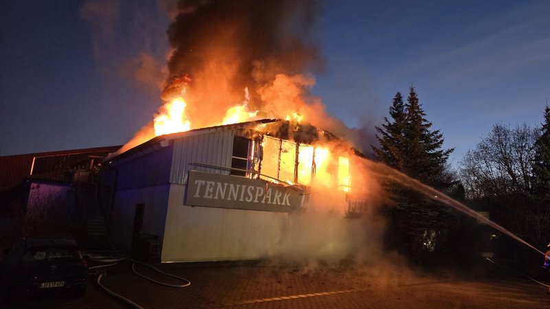Flammen schlagen aus dem Dach einer Halle mit der Aufschrift "Tennispark". | Bild: NEWS5 / Ferdinand Merzbach Flammen schlagen aus dem Dach einer Halle mit der Aufschrift "Tennispark".