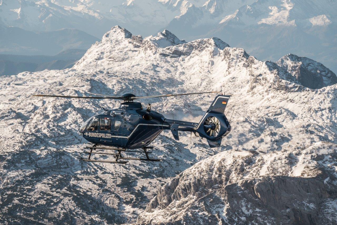 Ein dunkelblauer Bundespolizeihubschrauber vor schneebedeckten Bergen (Archivbild)