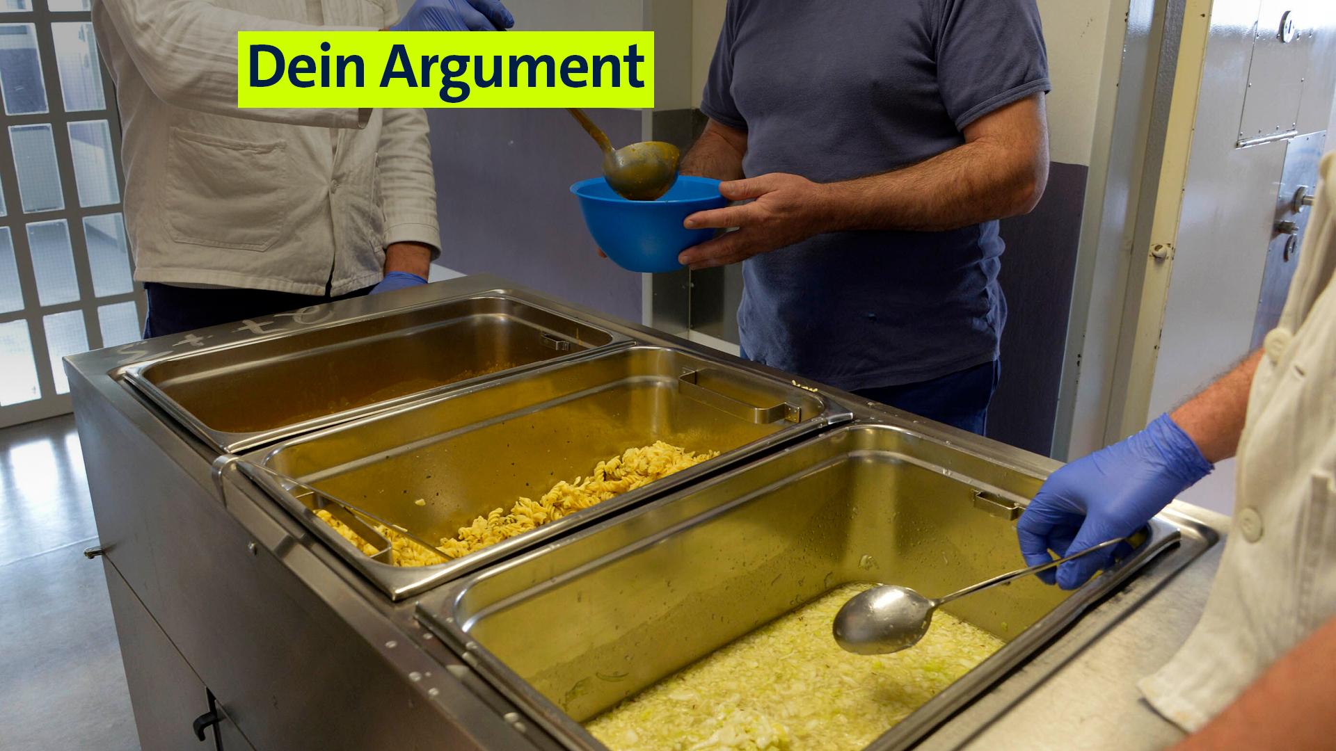 Archivbild: Essensausgabe in der JVA Stadelheim in München: Drei Männer stehen an einer Essensausgabe im Gefängnis.