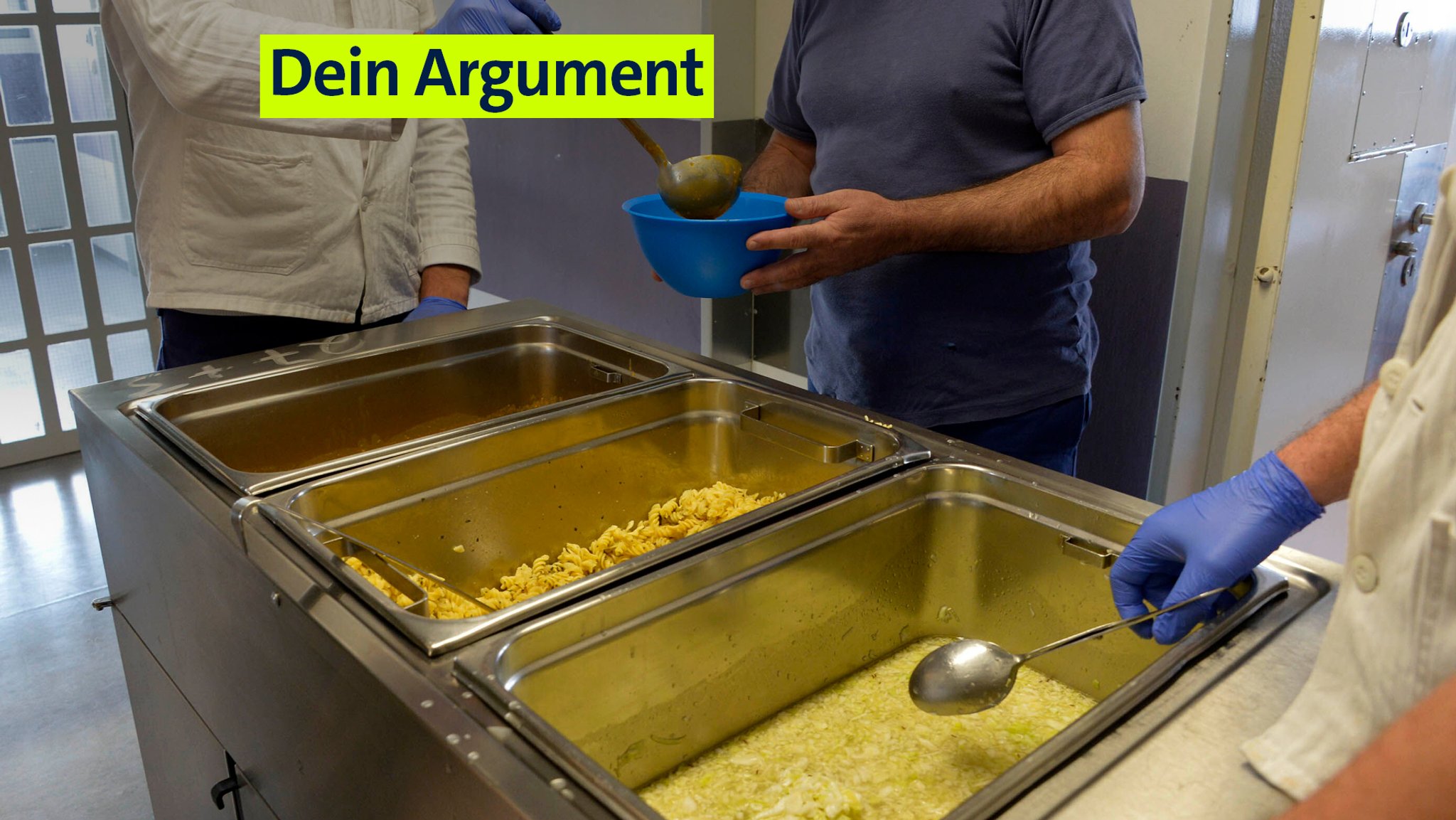 Archivbild: Essensausgabe in der JVA Stadelheim in München: Drei Männer stehen an einer Essensausgabe im Gefängnis.