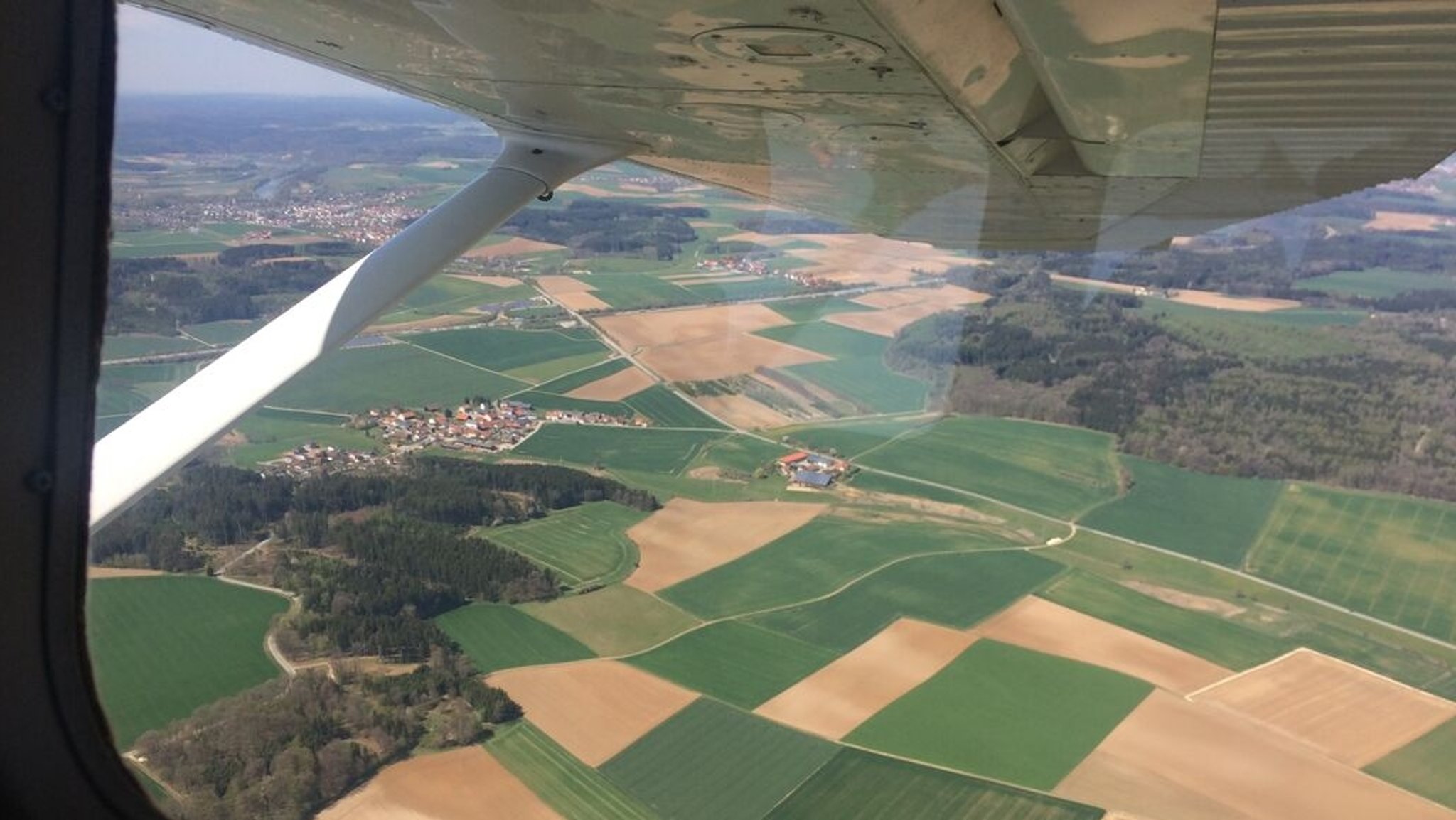 Blick aus dem Cockpit eines Kleinflugzeugs auf die Landschaft