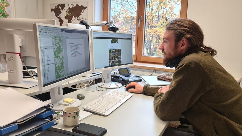 Digitalranger Lukas Nietsch sitzt vor seinem Rechner und überprüft digitale Routenvorschläge im Internet auf ihre Umweltverträglichkeit.