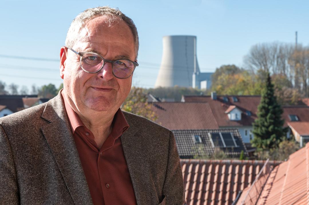 Ein Mann mit einem Kühlturm im Hintergrund