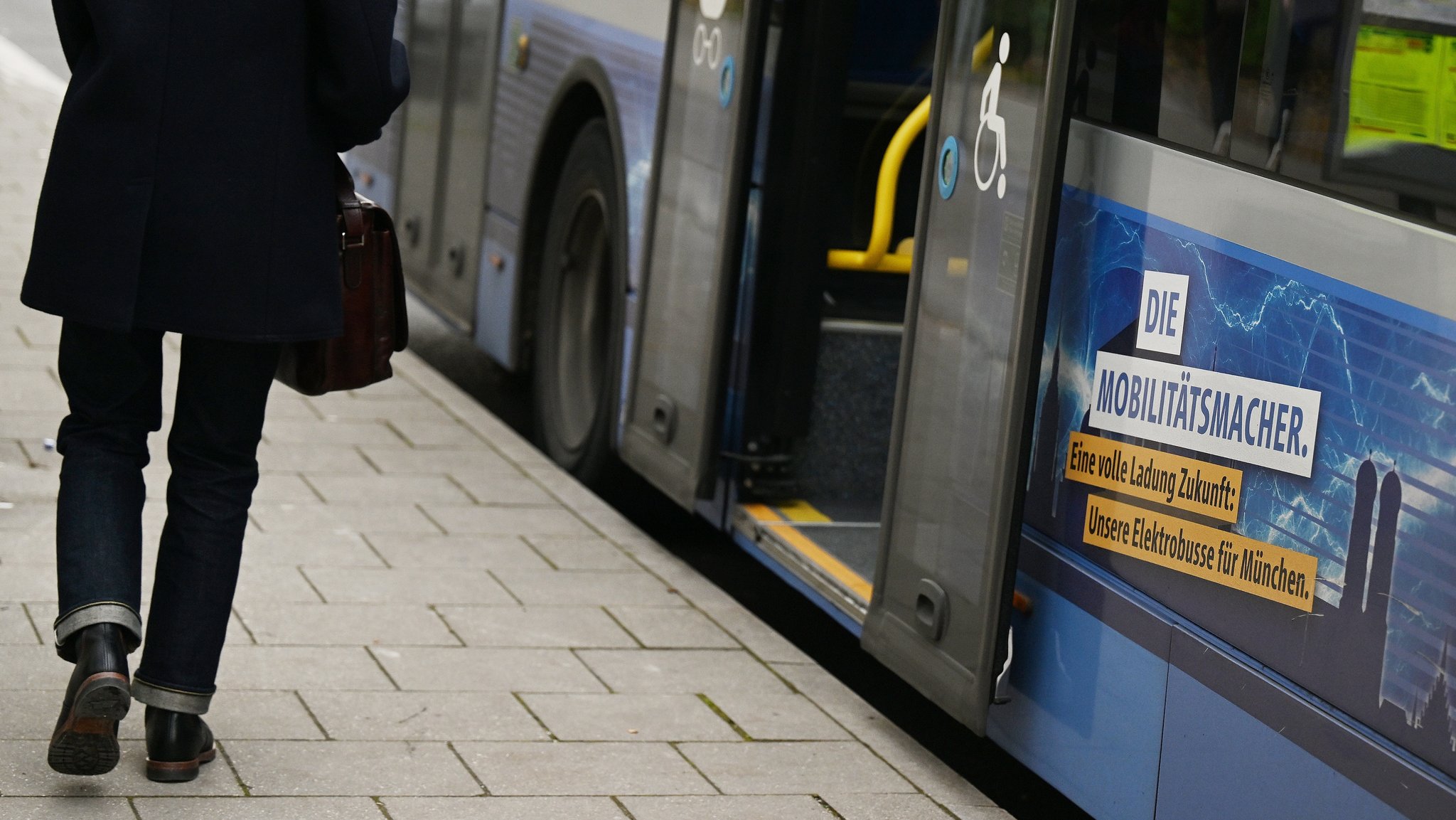 Jemand läuft in Richtung E-Stadtbus der Münchner Verkehrsgesellschaft