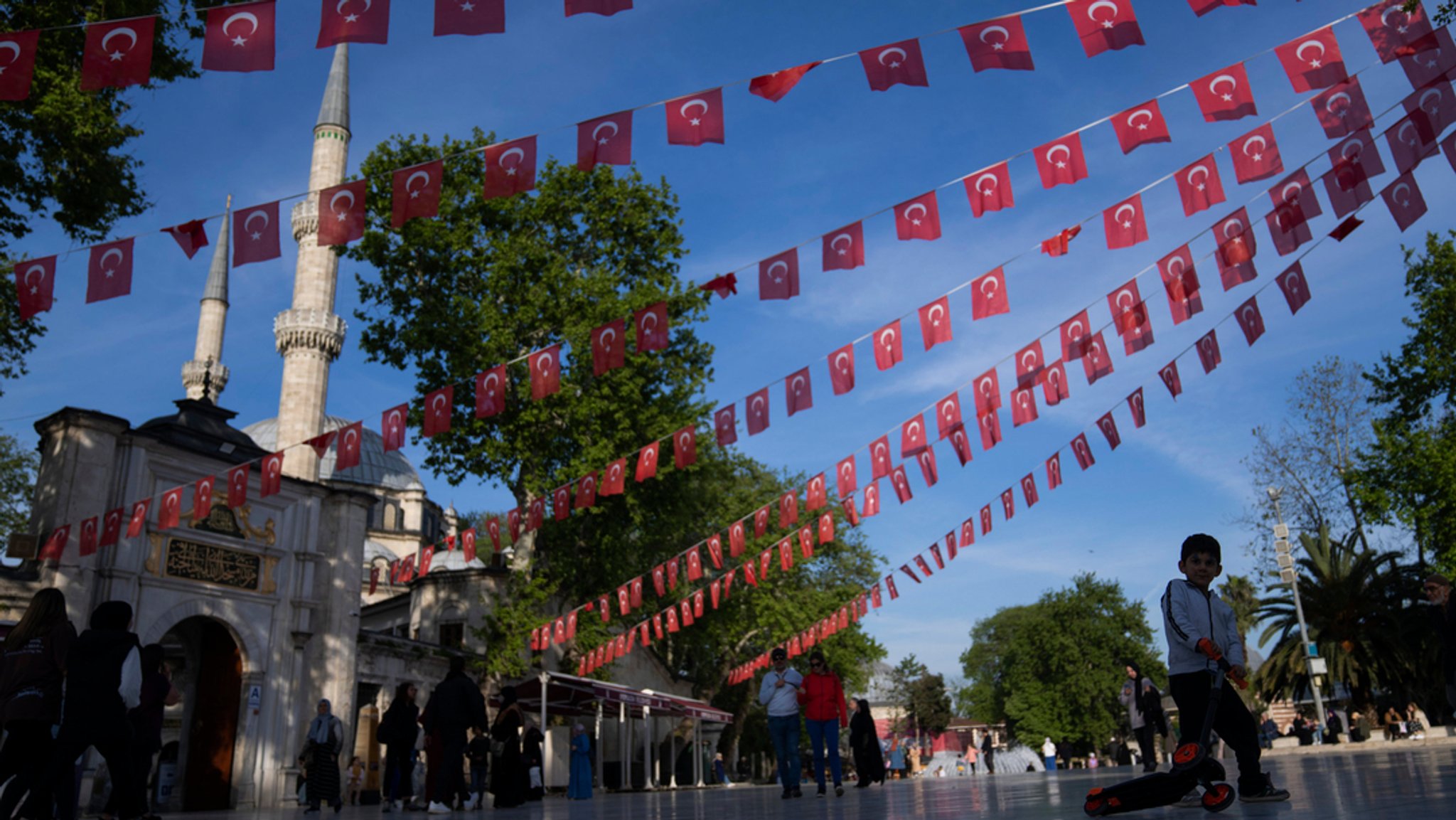 Türkei, Istanbul: Ein Junge spielt unter türkischen Fahnen, die neben der Eyub-Sultan-Moschee dekoriert sind.