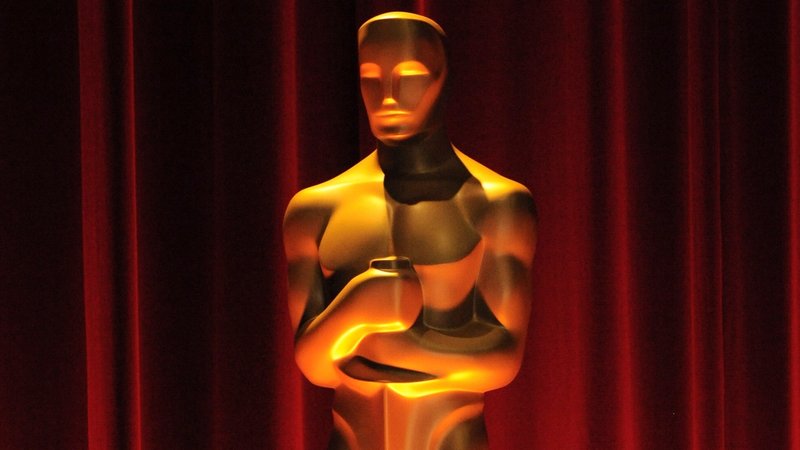 Eine von oben beleuchtete Oscar-Statue vor einem rotem Vorhang | Bild: picture alliance / Everett Collection | Elizabeth Goodenough/Everett Collection Eine von oben beleuchtete Oscar-Statue vor einem rotem Vorhang