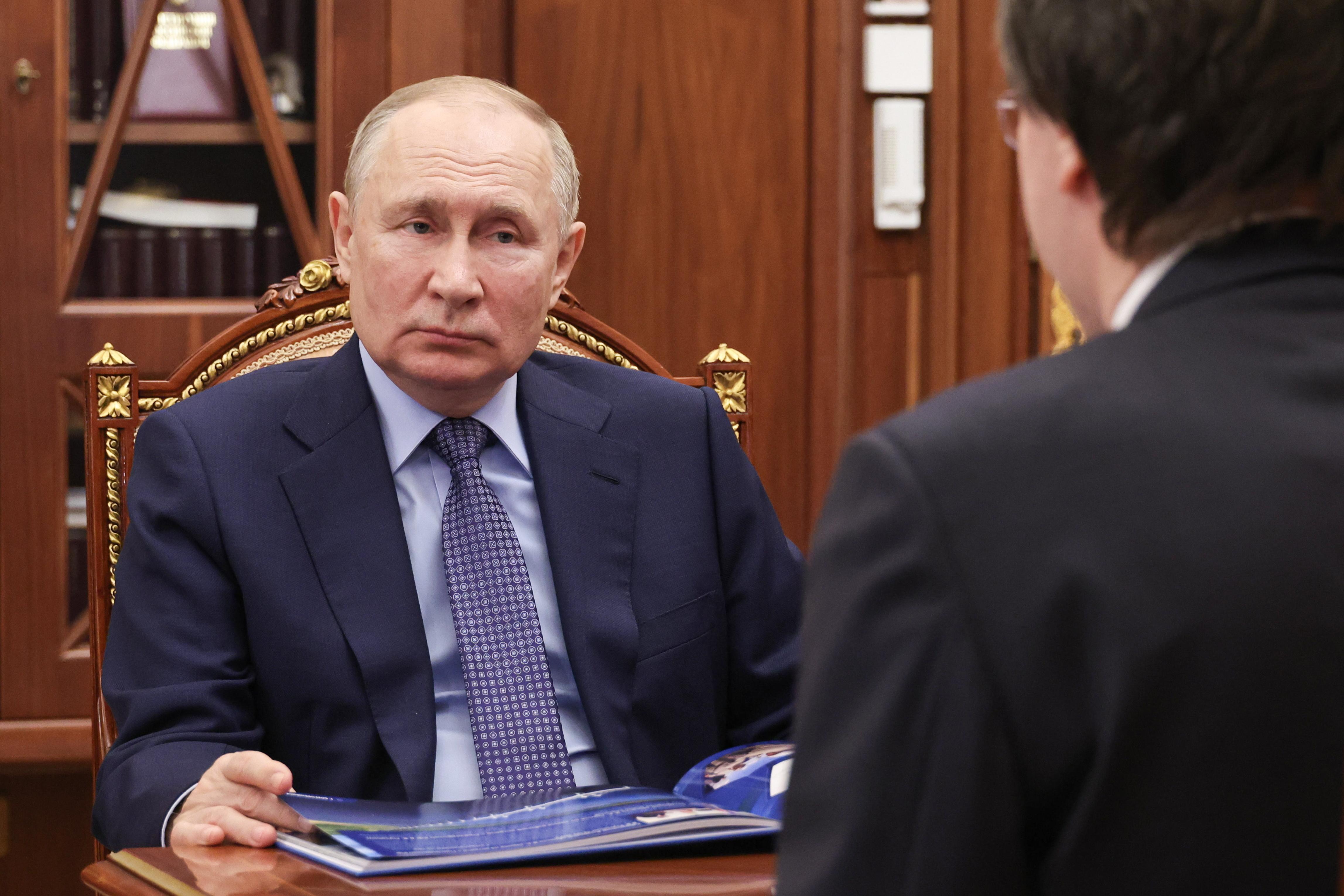 Der russische Präsident sitzt auf einem Sessel mit vergoldetem Holzrahmen