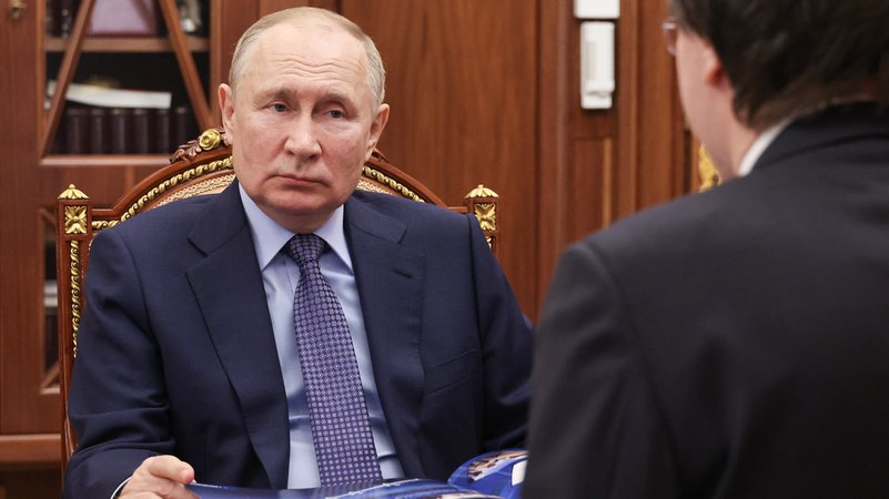 Der russische Präsident sitzt auf einem Sessel mit vergoldetem Holzrahmen