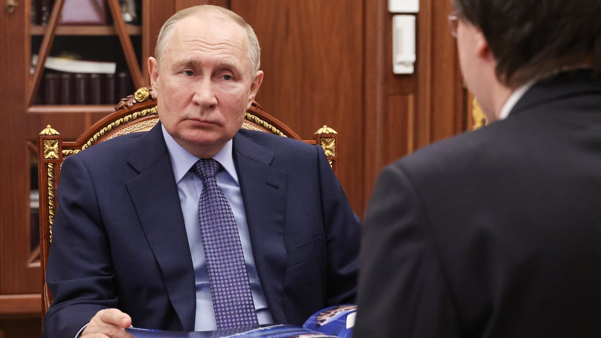 Der russische Präsident sitzt auf einem Sessel mit vergoldetem Holzrahmen