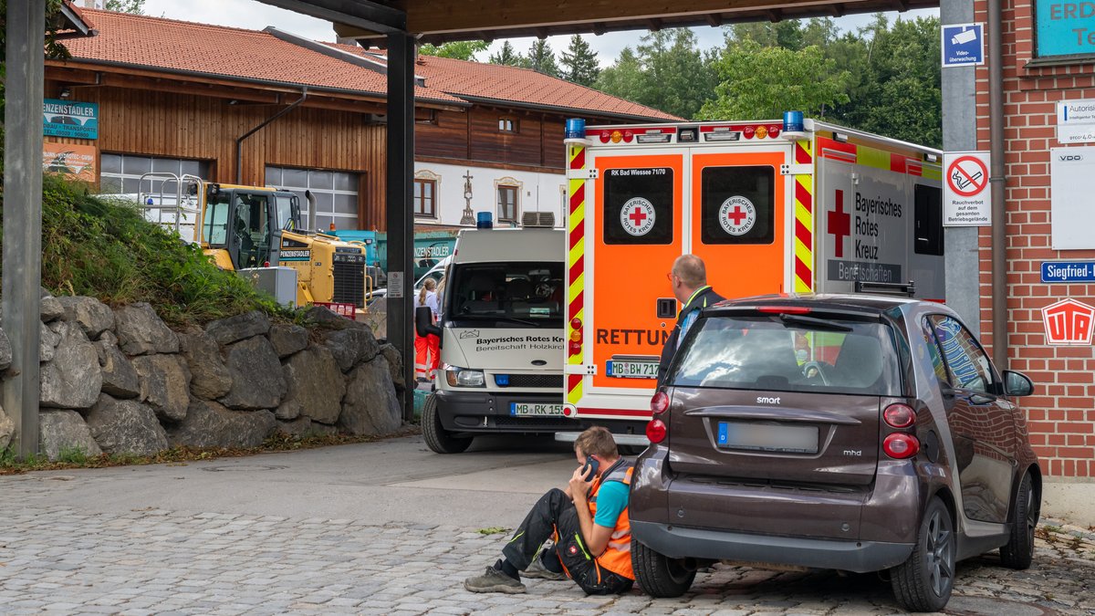 Ein Krankenwagen steht in der Einfahrt eines Unternehmens.