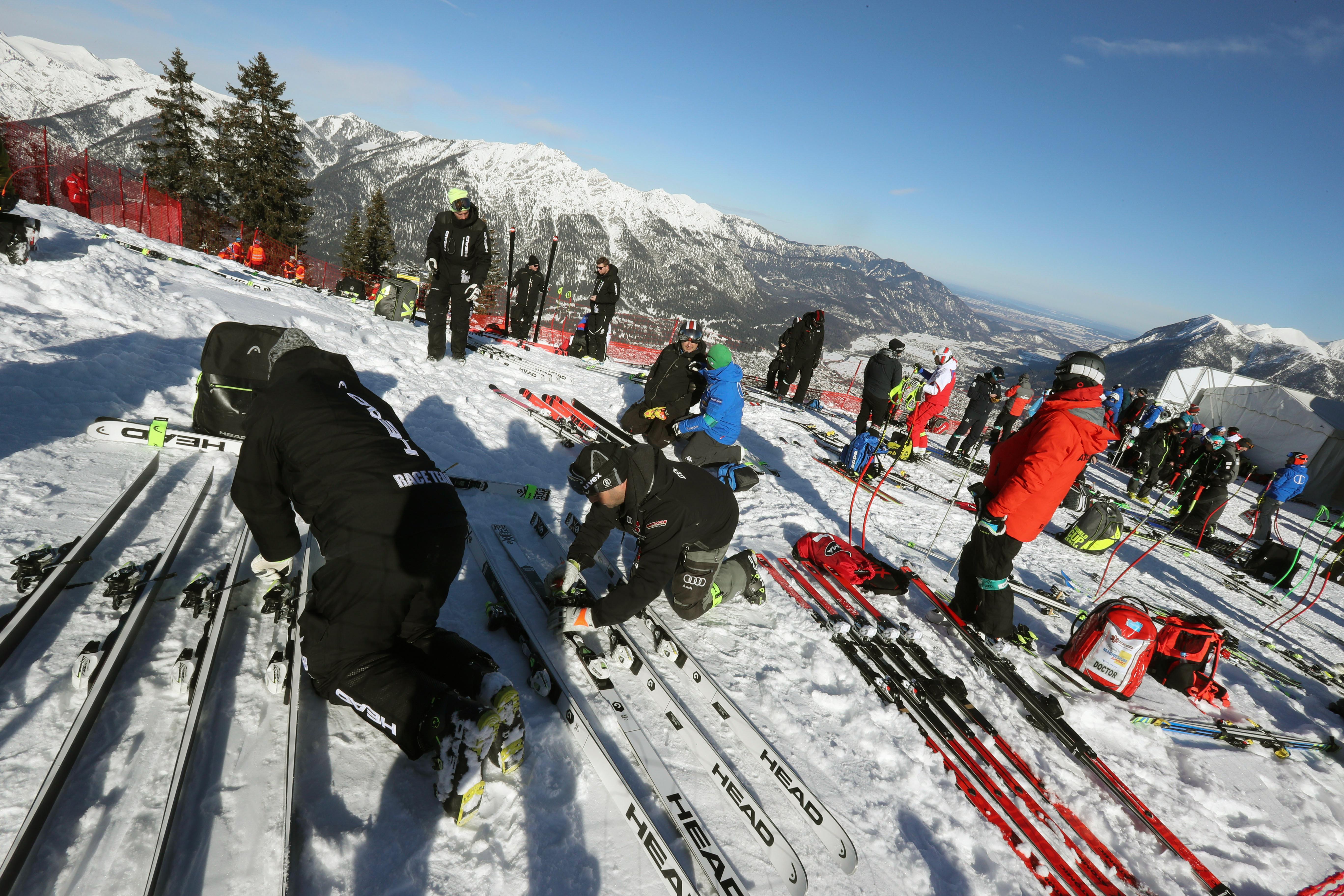 Servicemänner bereiten die Skier am Start eines Rennens vor