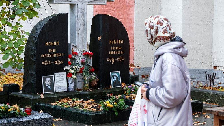 Friedhofsbesucherin mit Kopftuch schaut auf Grabstein | Bild:picture alliance/dpa/TASS | Valery Sharifulin