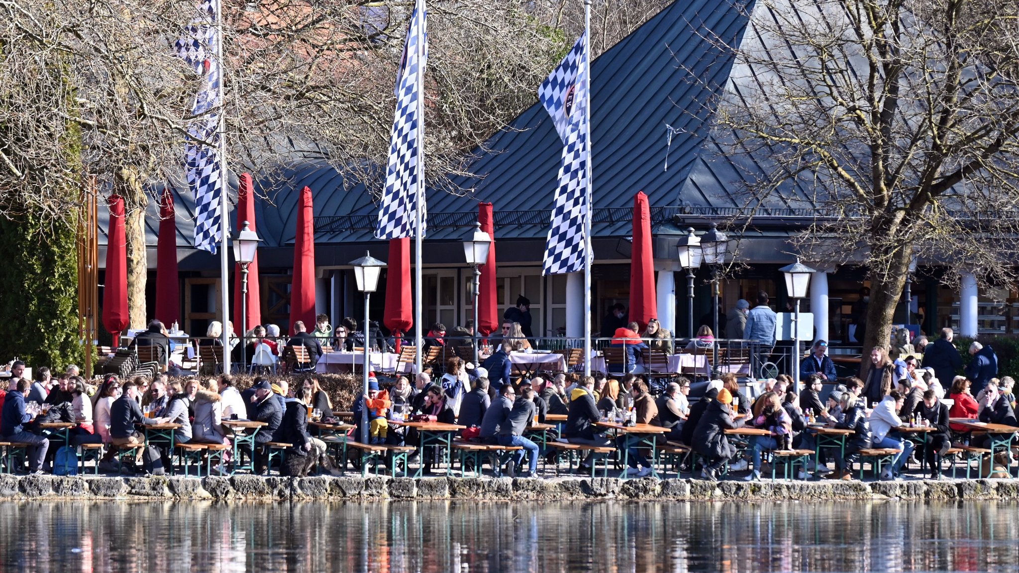 13.02.22: Zahlreiche Menschen sitzen in einem Biergarten im Englischen Garten in München.