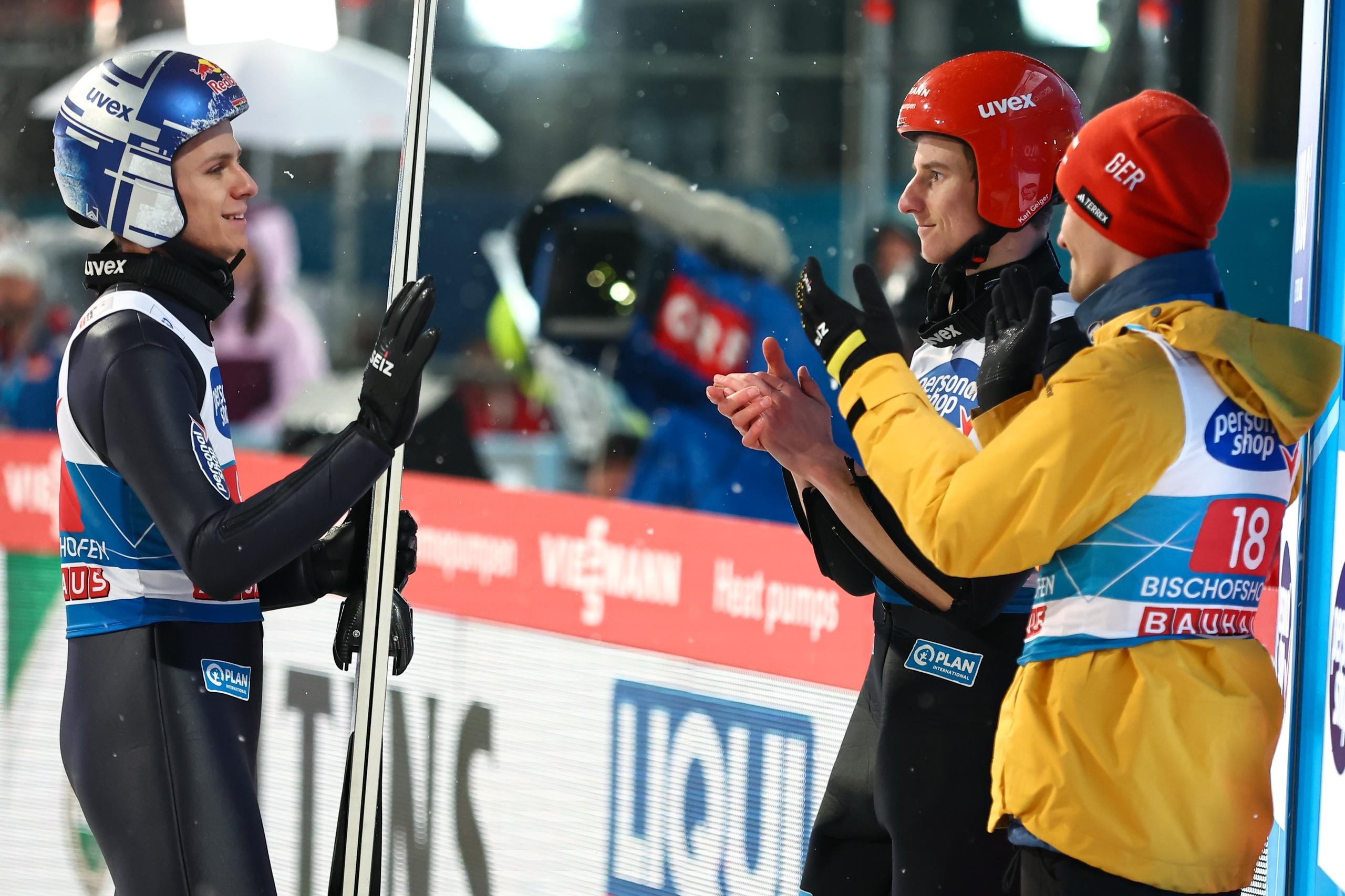 Der Deutsche Andreas Wellinger (l) gestikuliert im Zielbereich. Die Deutschen Deutsche Stephan Leyhe (r) und und Karl Geiger (M) applaudieren.