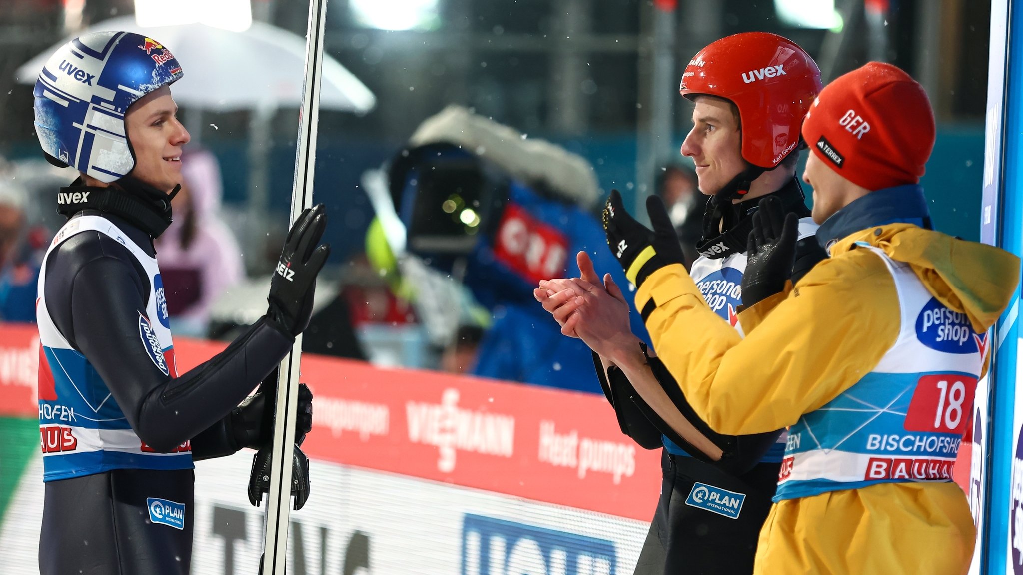 Der Deutsche Andreas Wellinger (l) gestikuliert im Zielbereich. Die Deutschen Deutsche Stephan Leyhe (r) und und Karl Geiger (M) applaudieren.