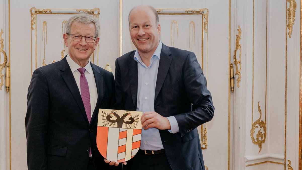 Der schwäbische Bezirkstagspräsident Martin Sailer und sein Stellvertreter Peter Schiele halten das Wappen des Bezirks Schwaben.