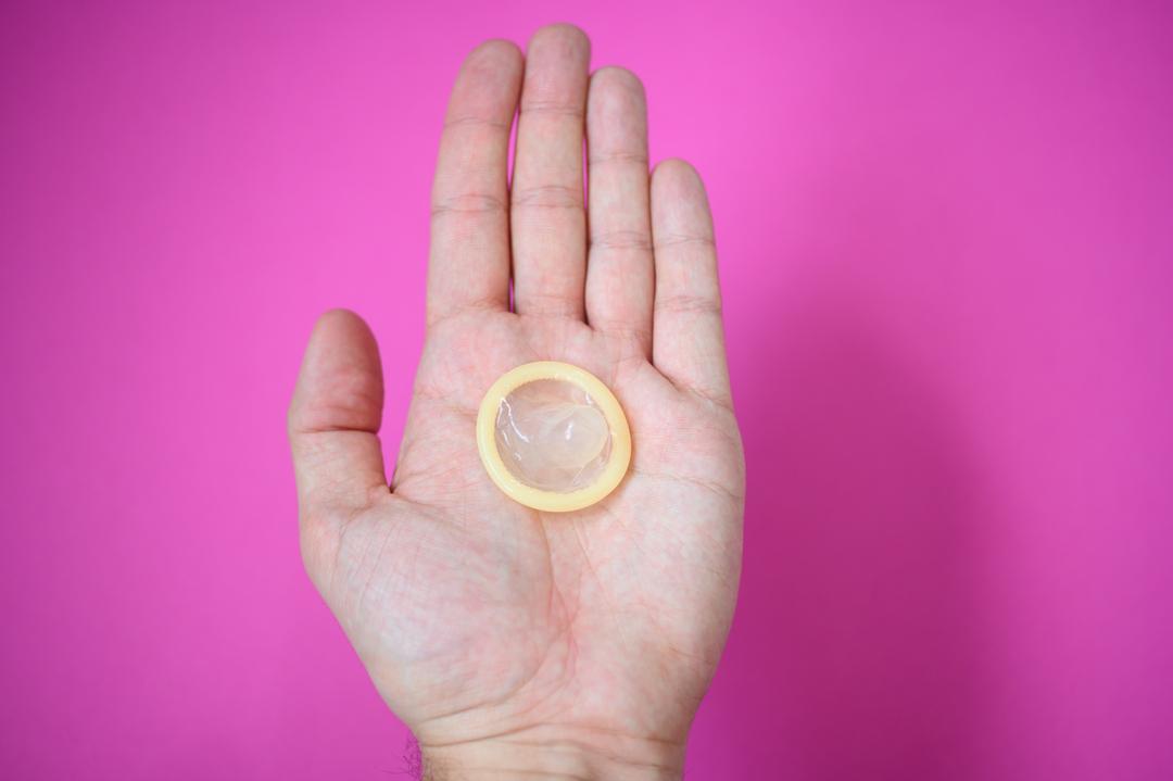 Ein Kondom in einer Hand.