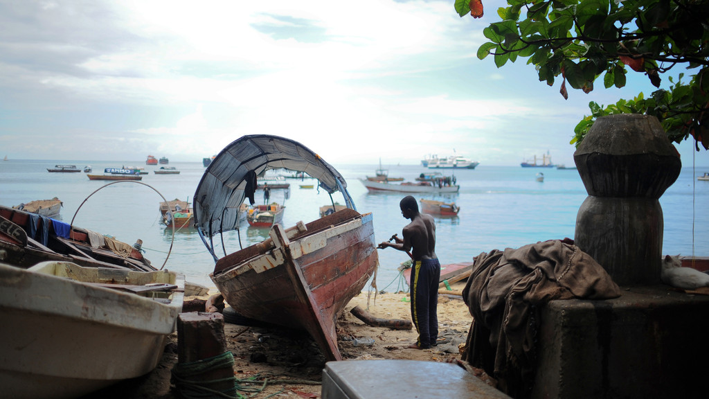 Bootsbauer in Stone Town auf Sansibar in Tanzania bei der Arbeit: Die traditionellen Boote Ostafrikas werden immer noch in Handarbeit gebaut. Sie sind das wichtigste Transportmittel an der Küste, schnell und wendig.