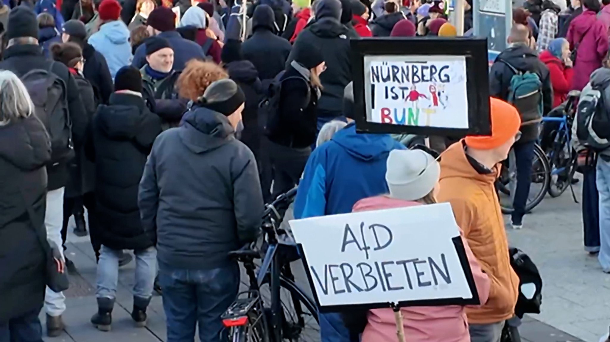 Menschen mit Plakaten stehen auf einem Platz